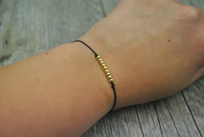 Armband mit goldenen Kugeln und Band in schwarz